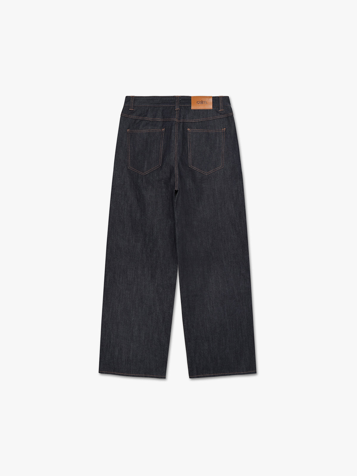 Raw indigo baggy jeans seen from the back with Calm logo leather patch